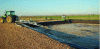 Figure 4 - Digestate storage lagoon (liquid, but solid on the surface) whose tractor gives an idea of the size of the basin.