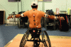 Figure 2 - Photograph of an athlete in a wheelchair during simultaneous measurements of his kinematics with an optoelectronic system and a system of two inertial units placed respectively on the wheelchair frame and on its trunk.